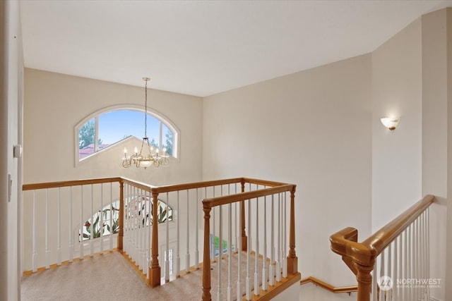 staircase featuring carpet floors and an inviting chandelier