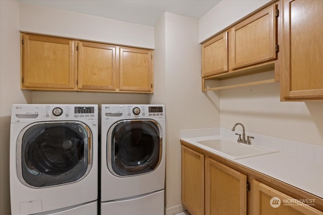 washroom with cabinets, separate washer and dryer, and sink