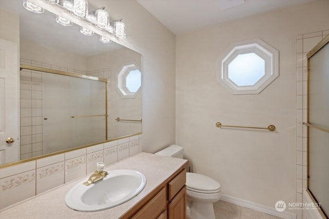 bathroom with tile patterned flooring, vanity, toilet, and walk in shower