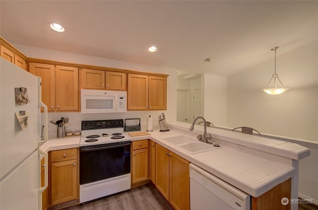 kitchen with kitchen peninsula, white appliances, dark hardwood / wood-style floors, and sink