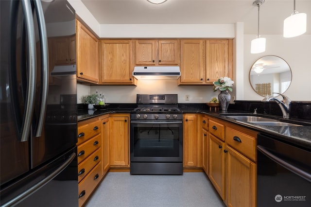 kitchen featuring hanging light fixtures, dark stone counters, sink, and black appliances