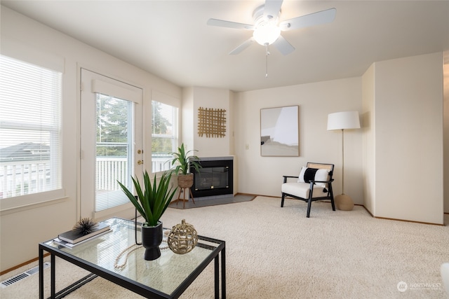 living area featuring ceiling fan and carpet flooring