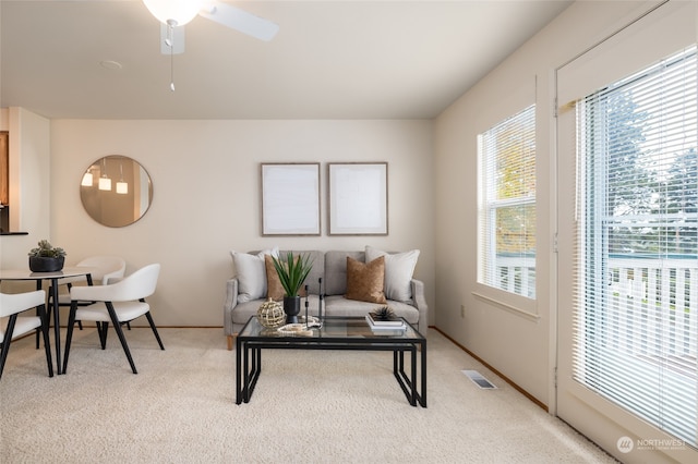 carpeted living room with ceiling fan and a healthy amount of sunlight