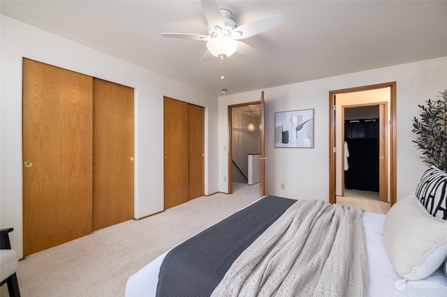 carpeted bedroom featuring two closets and ceiling fan