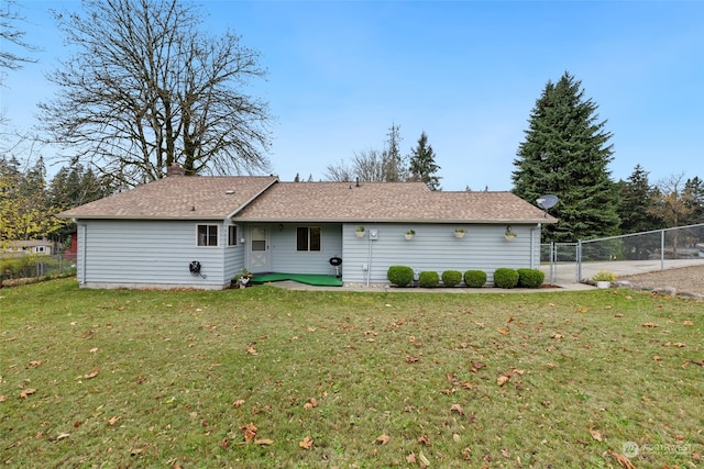 rear view of house featuring a lawn