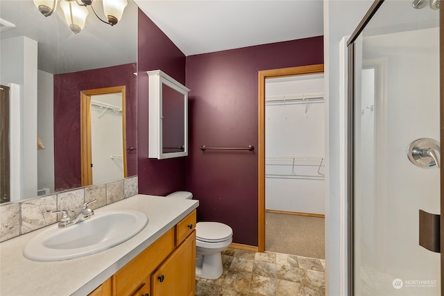 bathroom featuring vanity, an enclosed shower, and toilet