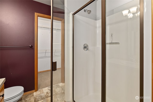 bathroom featuring toilet, vanity, and walk in shower