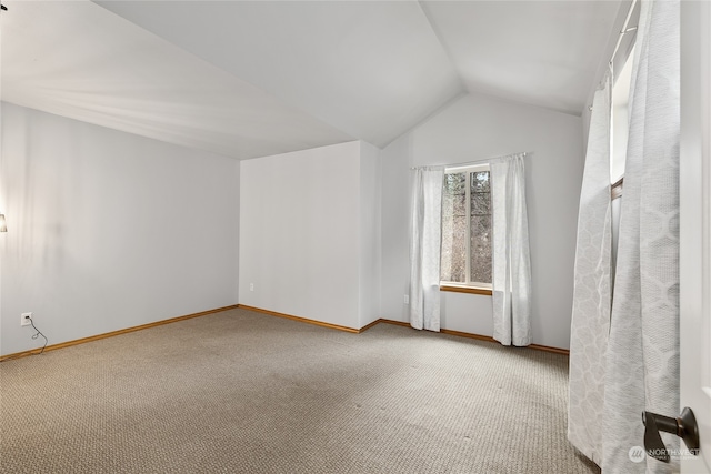 carpeted spare room with lofted ceiling