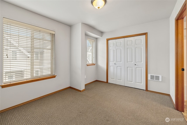 unfurnished bedroom with light carpet and a closet