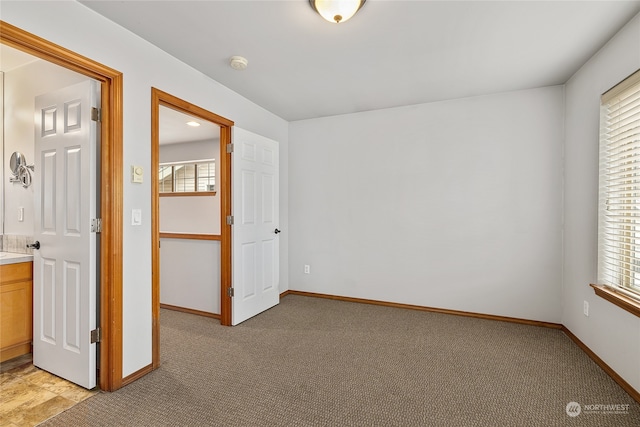 interior space featuring connected bathroom and light colored carpet