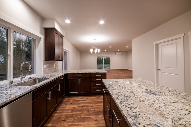 kitchen with tasteful backsplash, dark wood-type flooring, decorative light fixtures, dishwasher, and a chandelier