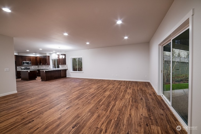 unfurnished living room featuring dark hardwood / wood-style flooring and a chandelier