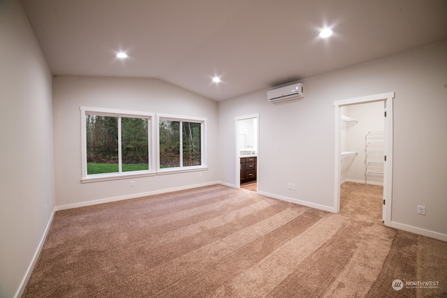 interior space with vaulted ceiling and a wall mounted air conditioner