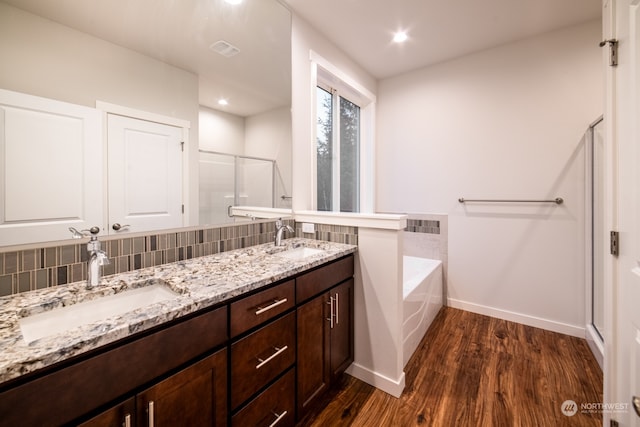 bathroom featuring wood-type flooring, vanity, tasteful backsplash, and separate shower and tub