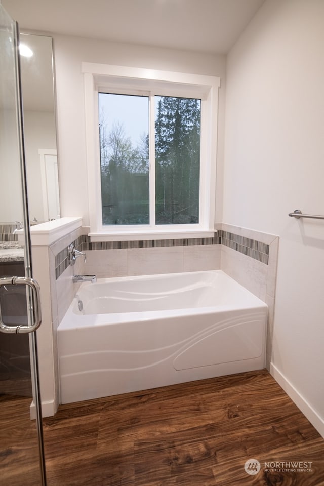 bathroom featuring a bath and hardwood / wood-style flooring