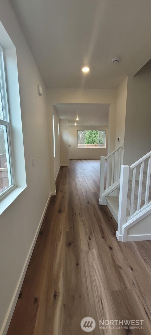 hallway featuring recessed lighting, baseboards, wood finished floors, and stairs