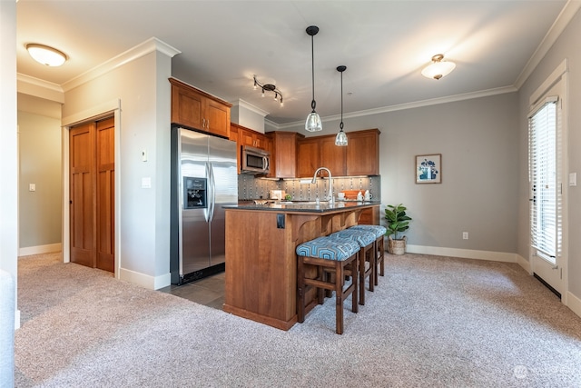 kitchen with a center island with sink, decorative light fixtures, a healthy amount of sunlight, and stainless steel appliances