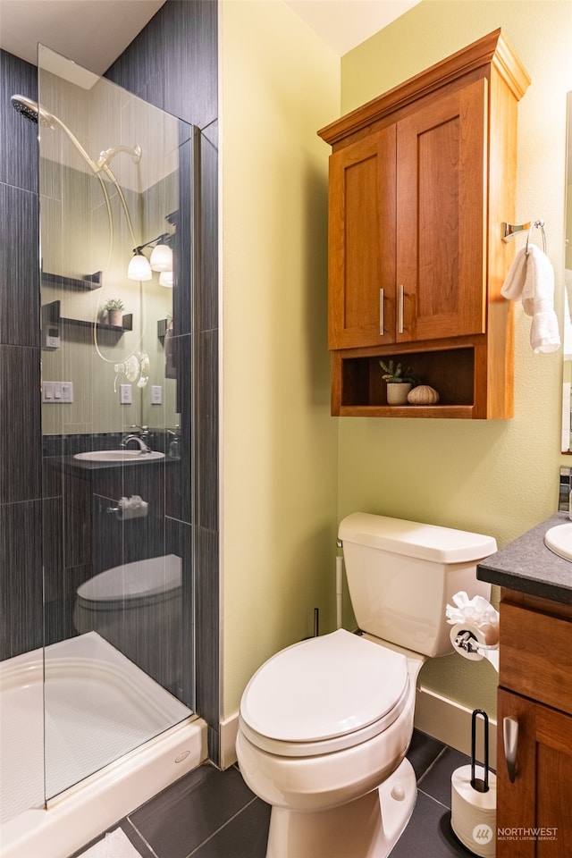 bathroom with tile patterned flooring, vanity, an enclosed shower, and toilet