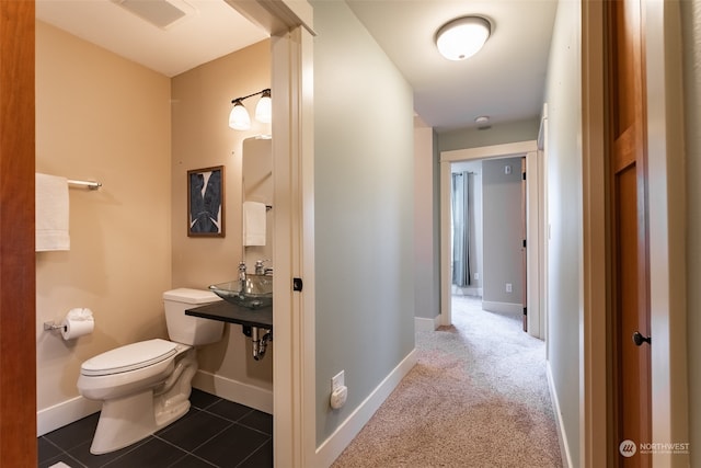 bathroom with tile patterned flooring, toilet, and sink