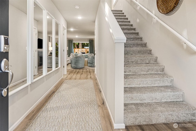 stairs featuring recessed lighting, baseboards, and wood finished floors