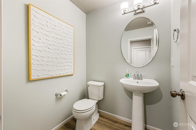 bathroom with hardwood / wood-style floors, sink, and toilet