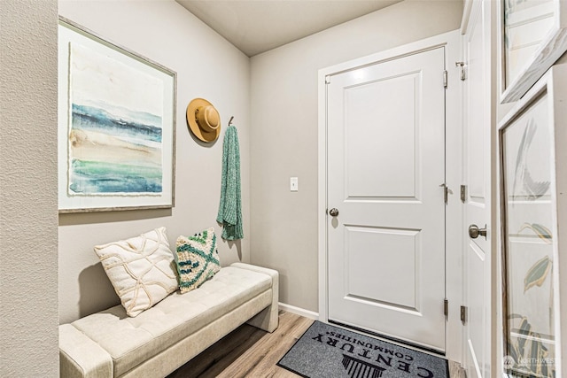 doorway to outside featuring wood finished floors and baseboards