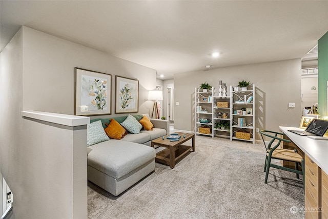 living area with light colored carpet and baseboards