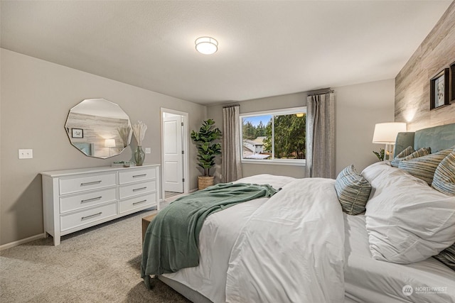 bedroom featuring light carpet and baseboards