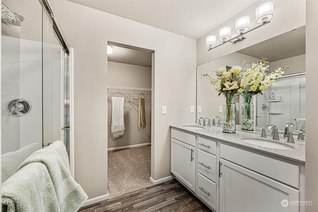 bathroom with a shower with door, wood-type flooring, and vanity