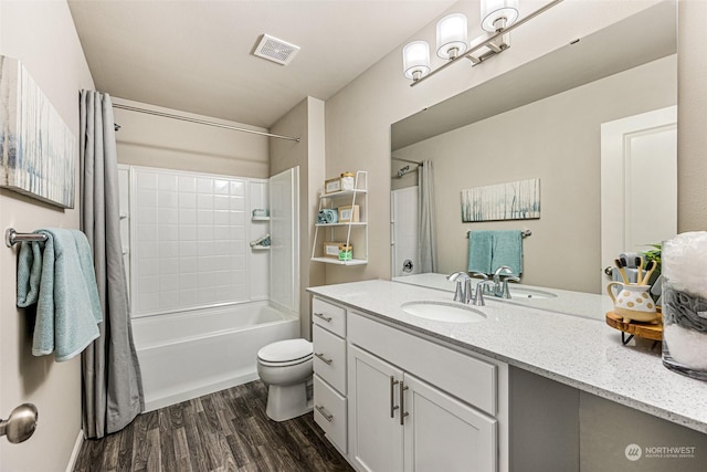 bathroom featuring vanity, wood finished floors, visible vents, shower / bath combo with shower curtain, and toilet