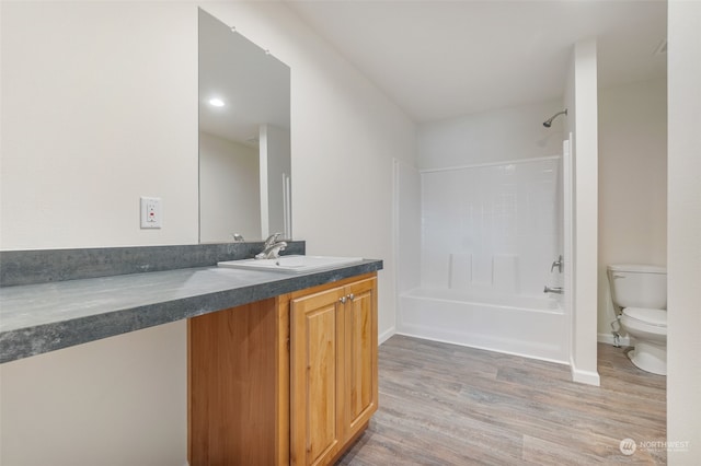 full bathroom with vanity, toilet, wood-type flooring, and shower / washtub combination