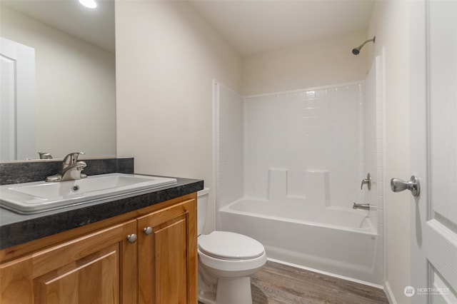 full bathroom with shower / washtub combination, hardwood / wood-style floors, vanity, and toilet