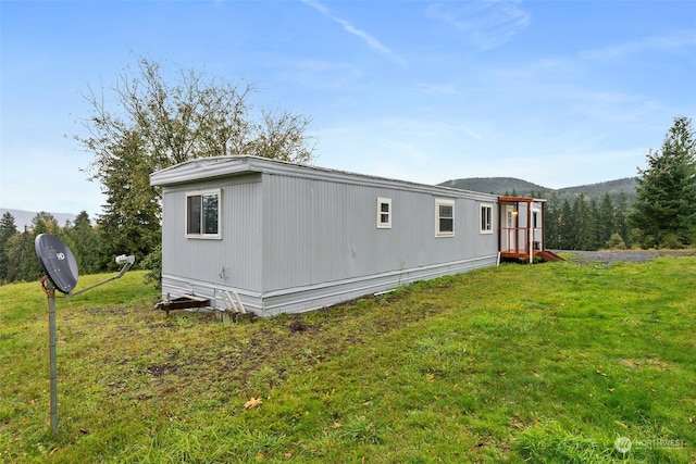 view of home's exterior featuring a mountain view and a lawn