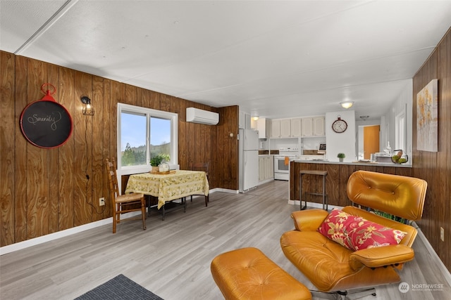 living room with a wall mounted air conditioner, light hardwood / wood-style floors, and wooden walls