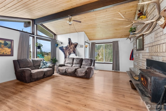 living room featuring wood ceiling, ceiling fan, lofted ceiling with beams, light hardwood / wood-style floors, and a wood stove