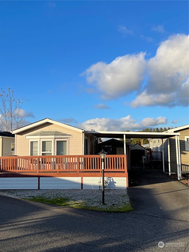 manufactured / mobile home featuring a wooden deck and a carport