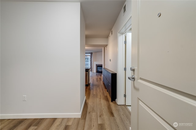 hallway with light hardwood / wood-style floors