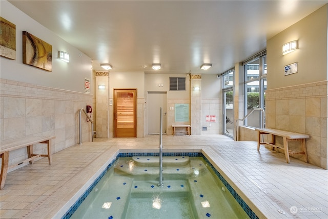 view of swimming pool featuring an indoor hot tub