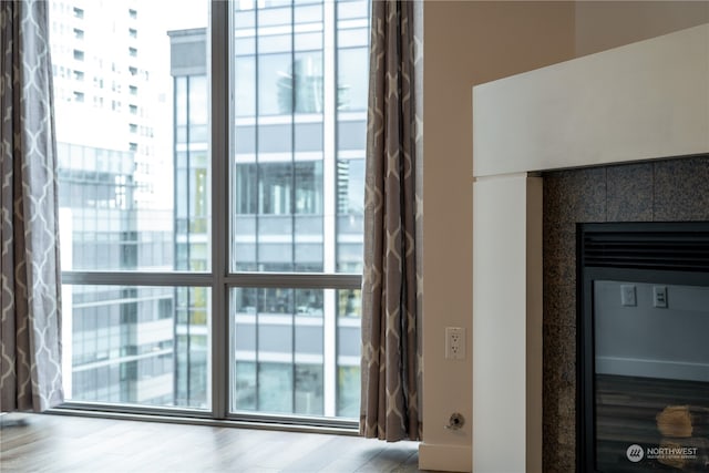 details featuring hardwood / wood-style flooring and a tiled fireplace