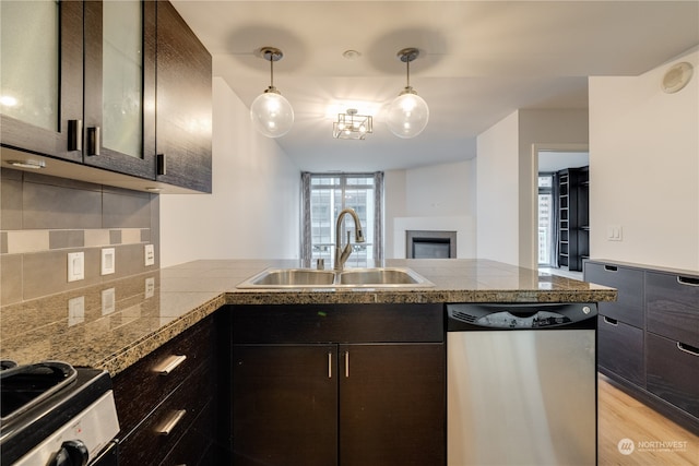 kitchen with dark brown cabinetry, sink, stainless steel appliances, decorative light fixtures, and light wood-type flooring