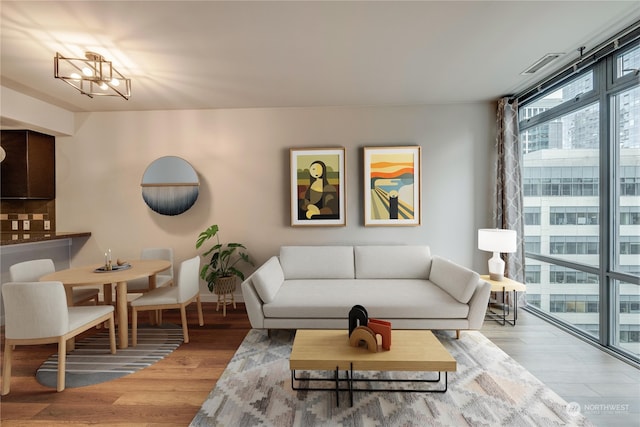 living room with hardwood / wood-style flooring and a notable chandelier