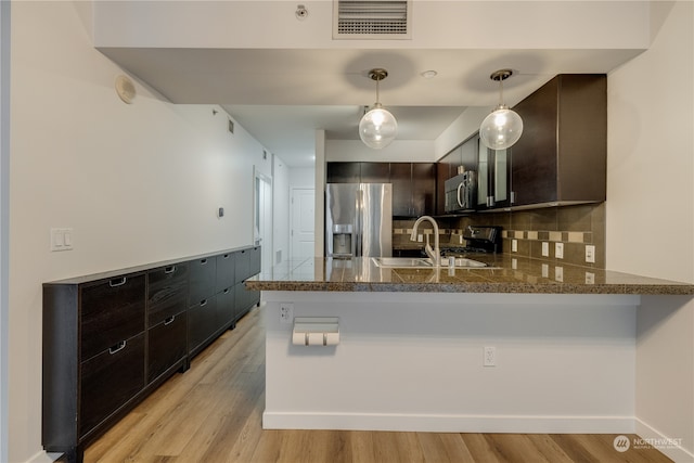 kitchen featuring dark brown cabinets, light wood-type flooring, kitchen peninsula, and appliances with stainless steel finishes