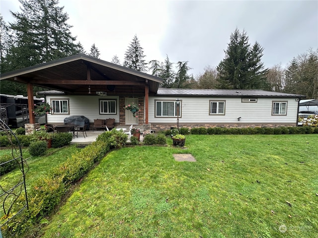 rear view of house featuring a patio area and a yard