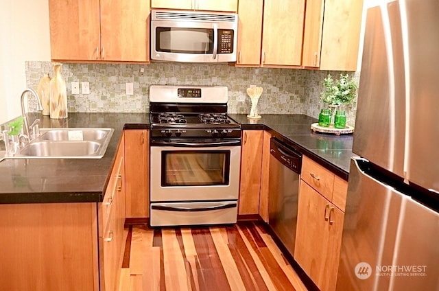 4333 9th Ave NE Unit C, Seattle, WA 98105 - kitchen with tasteful backsplash, sink, light wood-type flooring, and appliances with stainless steel finishes