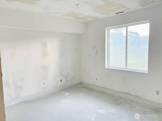 unfurnished room featuring a healthy amount of sunlight and concrete flooring