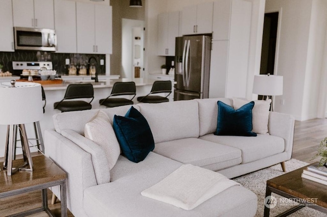 living room with light hardwood / wood-style floors and sink