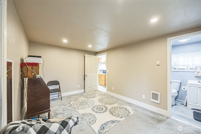 living area featuring a textured ceiling, light colored carpet, and heating unit