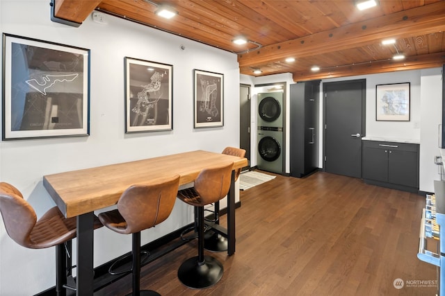 dining area with wood ceiling, dark hardwood / wood-style flooring, stacked washing maching and dryer, and beam ceiling