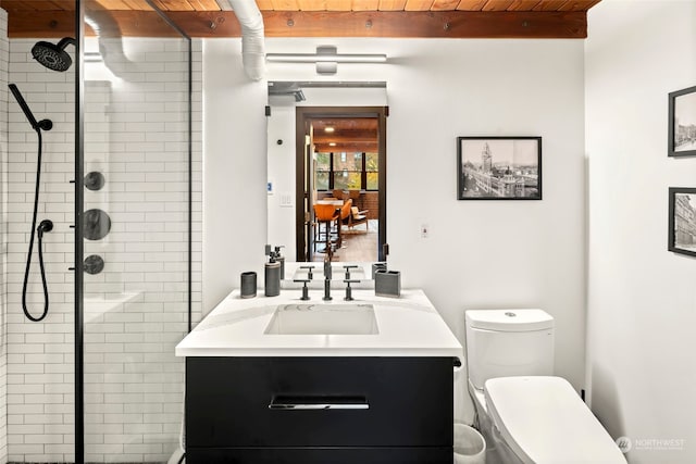 bathroom featuring wood ceiling, vanity, tiled shower, beamed ceiling, and toilet