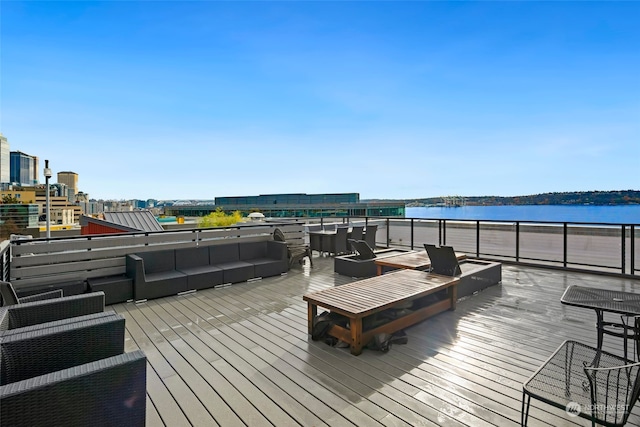 wooden terrace with an outdoor hangout area and a water view